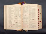 an open book with musical notations on it sitting on a table