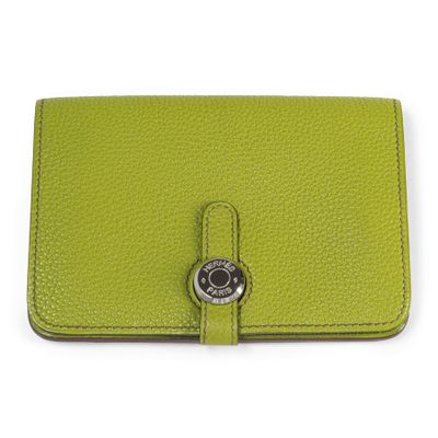 a green leather wallet with a metal button on the front