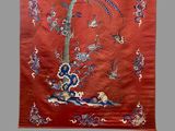 an image of a red wall hanging with birds and flowers on it