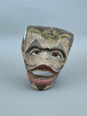 une sculpture en céramique représentant le visage d'un homme, la bouche ouverte