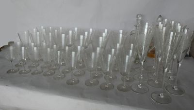 bottles and glasses are lined up on a table in front of a white wall