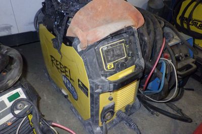 une soudeuse jaune et noire posée dans un garage