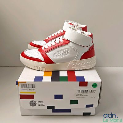 a white and red shoe on top of a box
