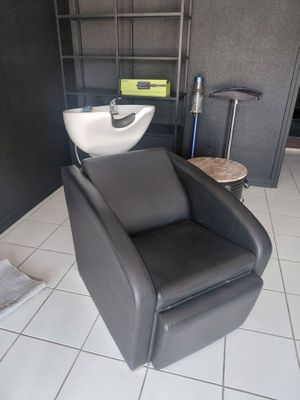 a black chair and a white sink in a room