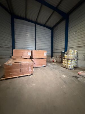 un grand entrepôt avec de nombreuses caisses par terre