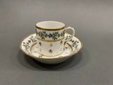 a cup and saucer on a plate on a table