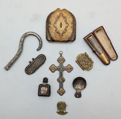un assortiment d'objets anciens, notamment une croix, un sac à main, un livre et d'autres objets