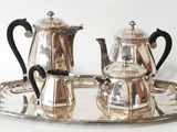 a silver tray with a silver tea set on it