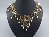 un collier vert et blanc orné de perles sur un mannequin noir