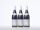 three bottles of wine are lined up on a table