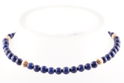 un gros plan d'un collier composé de perles bleues sur fond blanc