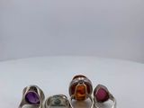 a group of rings with different colored stones on a white surface
