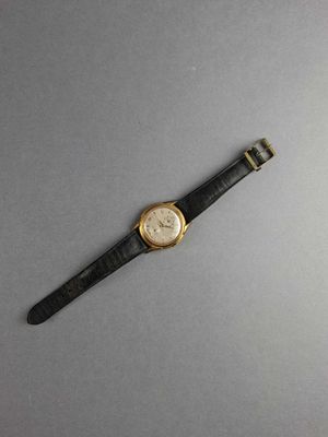 an image of a watch on a gray surface with a black strap