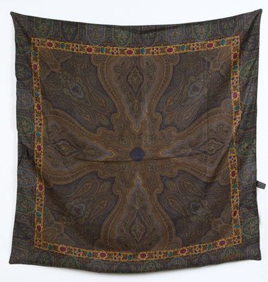 une écharpe à motifs paisley marron et bleus accrochée à un mur