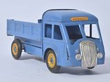 un petit camion jouet bleu posé sur une surface blanche