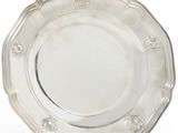 an antique silver plate on a stand on a white background