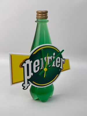 une bouteille verte ornée d'une horloge, posée sur une table