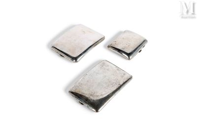 un gros plan sur trois boutons métalliques argentés posés sur une surface blanche