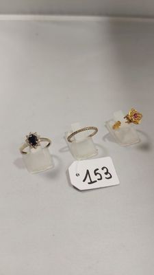 trois bagues et une bague posée sur une table, avec une étiquette indiquant son prix