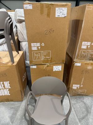 des cartons et des chaises empilés les uns sur les autres dans une pièce