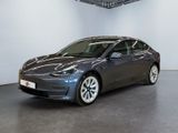 une Tesla Model 3 noire garée dans un garage