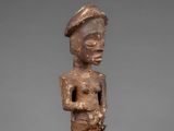 a wooden statue of a man with a hat on his head