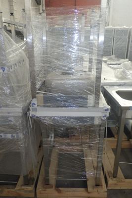 un gros tas de meubles emballés dans du plastique dans un entrepôt