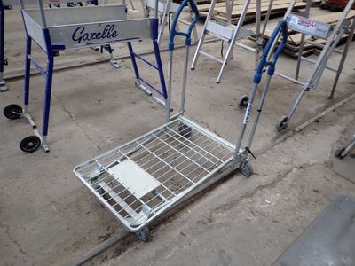 un caddie posé par terre à côté d'une pile de palettes