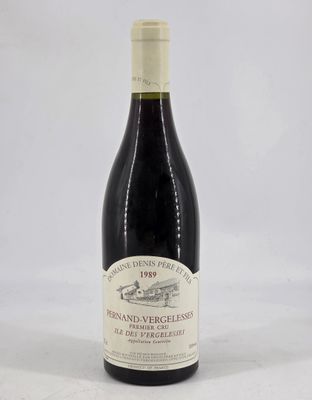 a bottle of red wine sitting on top of a white table