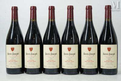 six bouteilles de vin sont alignées sur une table