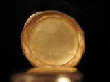 a close up view of a gold watch on a black surface