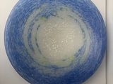 a blue and white bowl sitting on a white wall