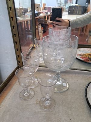 several empty wine glasses are sitting on a table in front of a glass case