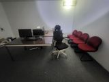 une pièce équipée d'un bureau, de chaises et d'un ordinateur posé dessus