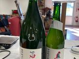 two bottles of wine sitting on a table next to each other