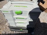 a green and white cooler sitting on top of a gravel ground