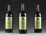 three bottles of wine are lined up on a table