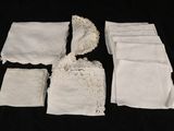 several pieces of white cloth with lace on them on a black background