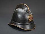 an old fireman ' s helmet with a gold emblem on it