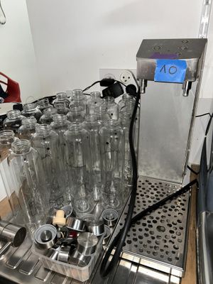 Des bouteilles d'eau sont alignées sur une machine dans une pièce