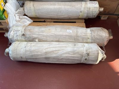 several rolls of cement sitting on top of a pallet in a warehouse