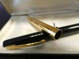 a black and gold fountain pen sitting in a box