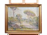 une peinture à l'huile représentant un paysage avec des arbres, posée sur un chevalet