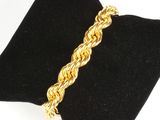 un gros plan d'un bracelet en or posé sur une serviette noire