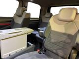 two seats in the back of a van with a tv on it