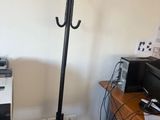 un bureau avec une imprimante et un porte-manteau dans un coin