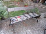 a wooden bench with a hat on it in the yard