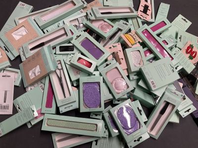 a pile of green and pink makeup products on a table