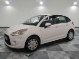 la petite voiture blanche est garée sur un carrelage à carreaux
