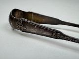 a spoon and tonget sitting on a white surface